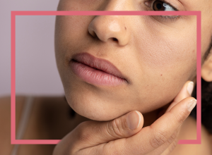 Frau schaut sich ihre trockene Haut an