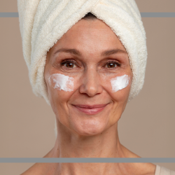 Frau cremt ihr Gesicht