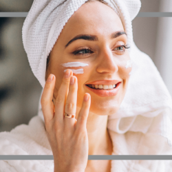 Frau cremt ihr Gesicht ein