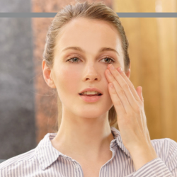 Frau benutzt Creme gegen trockene Haut